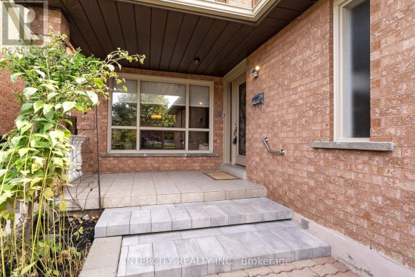 Covered front porch with stone steps and brick walls leading to the front door. - 57 Kaiser Drive, Vaughan