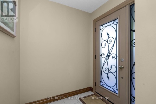 Interior view of an entryway with a beige door featuring decorative glass inserts. - 57 Kaiser Drive, Vaughan