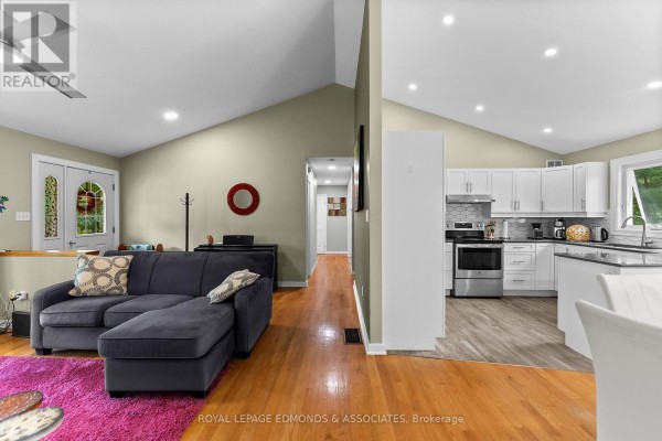 Living room with sectional sofa, piano, and vaulted ceiling, adjacent to kitchen - 57 Krause Street Laurentian Valley