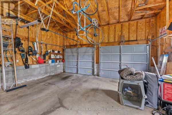 Two-car garage with storage shelves, tools, and bicycle hanging - 57 Krause Street Laurentian Valley