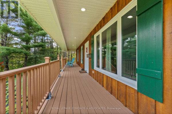 Covered porch with wooden deck and railing, large windows with green shutters - 57 Krause Street Laurentian Valley
