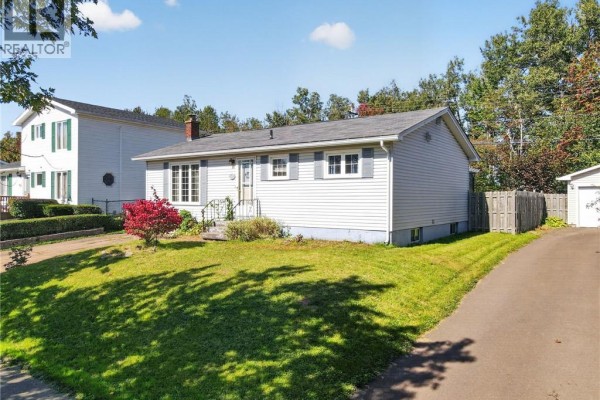 View of the front of the house from the driveway, showing siding, chimney, and garage. - 57 Labrosse Road, Moncton
