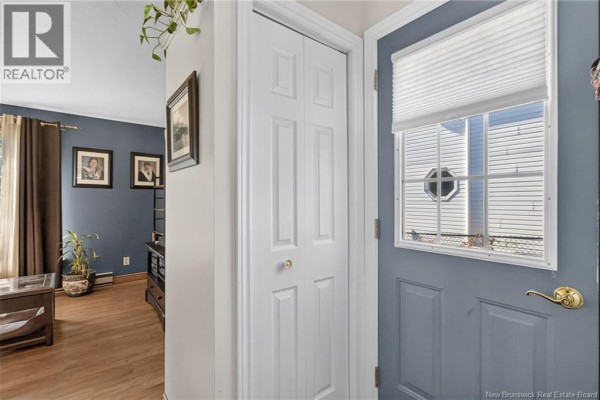 Interior entryway with white bi-fold closet doors and a blue front door with a window. - 57 Labrosse Road, Moncton