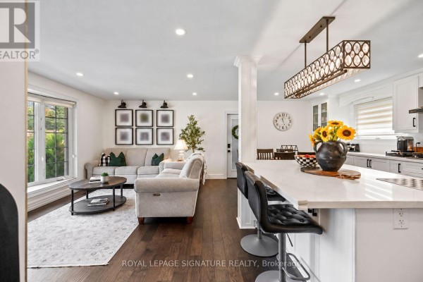 Open concept living room and kitchen with a sectional sofa and island. - 57 Sabrina Drive, Toronto