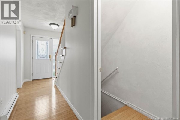 Interior view showing hallway, staircase, and door to a basement with painted walls. - 570 Mclaughlin, Moncton