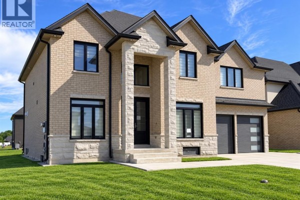 Front view of the stone and brick facade with a covered entryway and double garage. - 570 Orchards Crescent, Windsor
