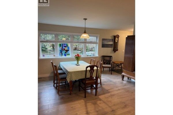 Shower area with glass enclosure, tiled walls, and built-in shelves for toiletries. - 5702 Medusa Street, Sechelt