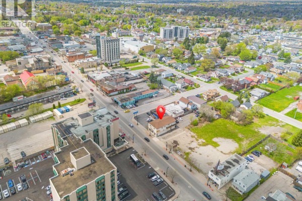 Aerial view of the commercial building located on a busy street surrounded by other buildings and trees. - 5703 Ferry Street, Niagara Falls