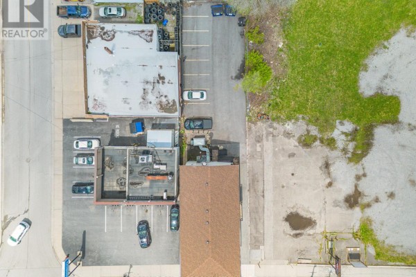 Overhead view of the commercial building, its parking lot, and surrounding undeveloped land. - 5703 Ferry Street, Niagara Falls