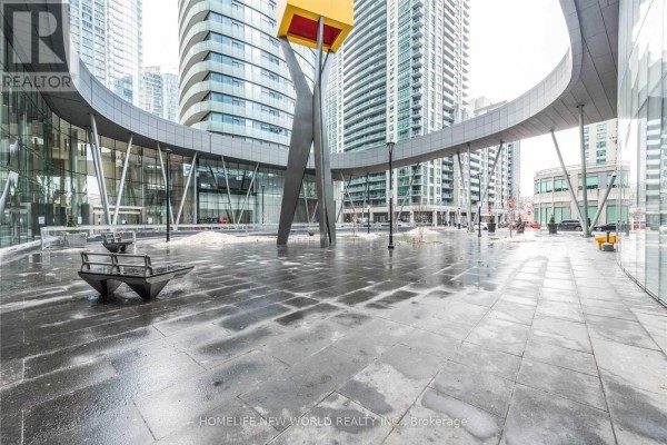 Modern outdoor plaza with contemporary sculpture, benches, and wet stone pavement. - 5709 - 14 York Street, Toronto