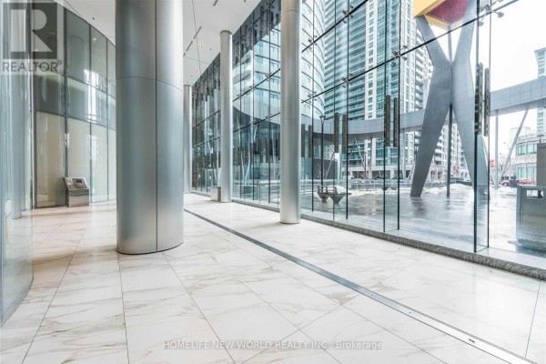Bright, modern lobby with marble floors, glass walls, and large cylindrical columns. - 5709 - 14 York Street, Toronto