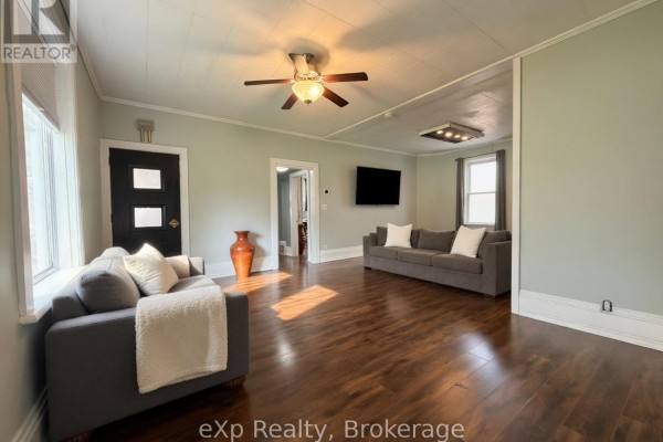 Spacious living room with two gray sofas, dark wood floors, and a ceiling fan. - 572 9th Avenue, Hanover