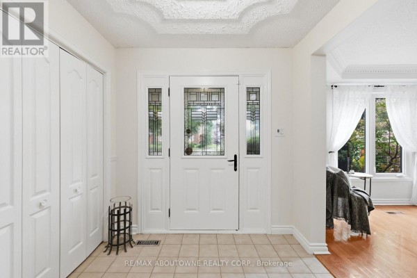 Interior front entrance with tiled floor, white walls, and double closet doors. - 572 Harmony Avenue, Burlington