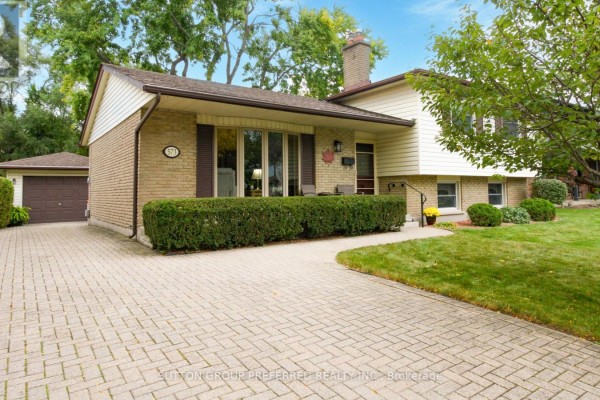 View of the driveway and front entrance of the house with brick and siding. - 573 Jamaica Court, London South