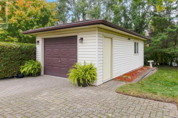 Detached single-car garage with a brown door and white siding. - 573 Jamaica Court, London South