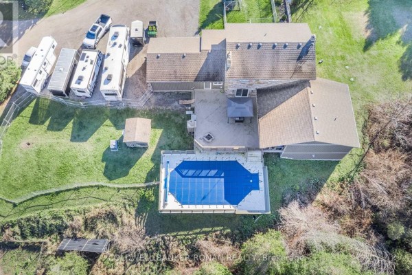 Aerial view of a house with a covered swimming pool and surrounding RVs and farm equipment. - 5735 Concession Rd 6, Adjala Tosorontio