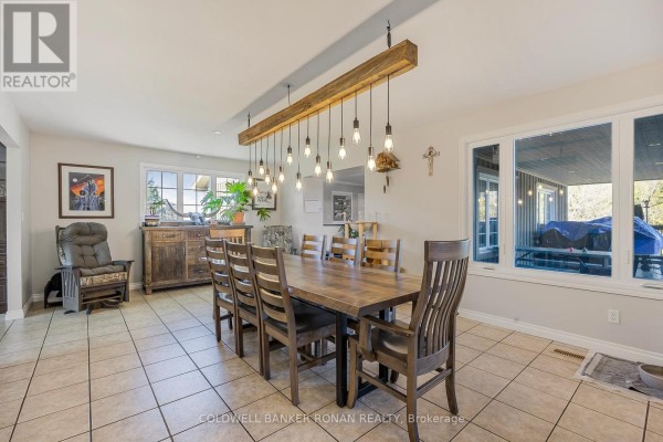 Dining room with a large wooden table, ten chairs, and a rustic hanging light fixture. - 5735 Concession Rd 6, Adjala Tosorontio