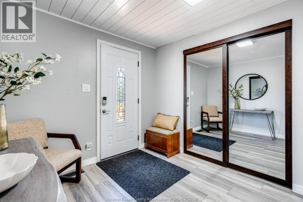 Interior entryway with a white front door, mirrored closet doors, and seating. - 574 Bevel Line, Leamington