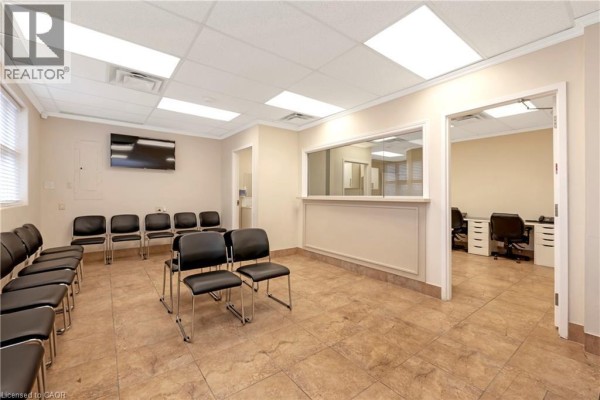 Interior waiting area with black chairs, tiled flooring, and a reception counter. - 574 Upper James Street, Hamilton