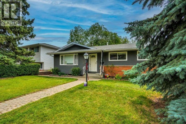 Circular patio design with interlocking pavers and glass railing overlooking a road. - 5748 Dalmead Crescent Nw, Calgary