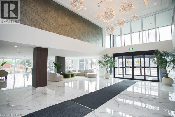 Spacious lobby with marble floors, modern seating, large windows, and decorative light fixtures. - 575 Conklin Road Unit# 1024, Brantford