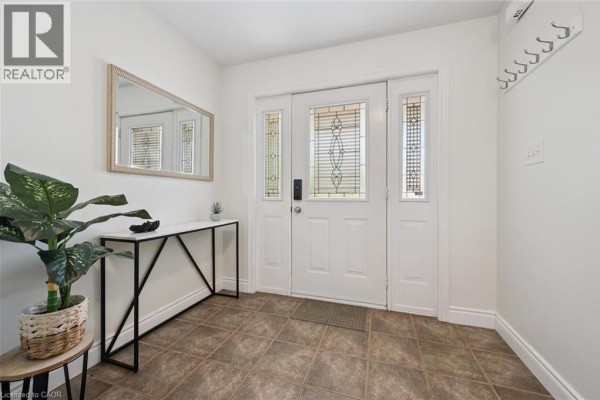 Front entryway with white door, sidelights, transom window, and floor tiles. - 575 Violet Street, Waterloo