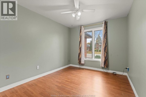 Empty room with light green walls, hardwood floor, and large window - 5753 Bishop Street, Lasalle
