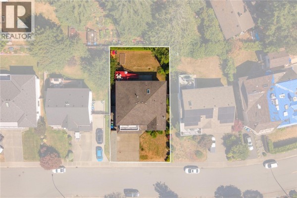 Overhead drone view showing the rectangular property lot, house, driveway, and surrounding residential homes. - 5771 Malibu Terr, Nanaimo