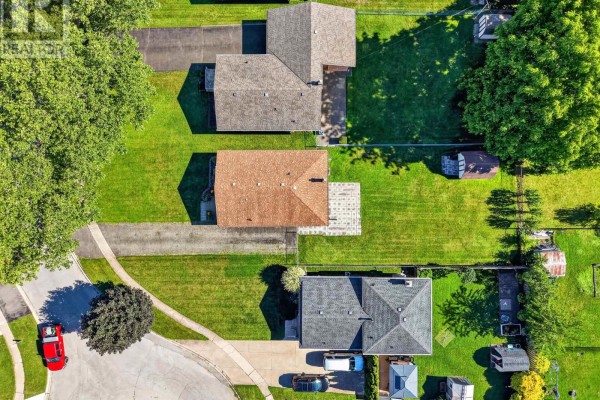 Aerial view showing a suburban neighborhood with distant city skyscrapers and waterfront. - 5777 Sunnylea Crescent, Niagara Falls