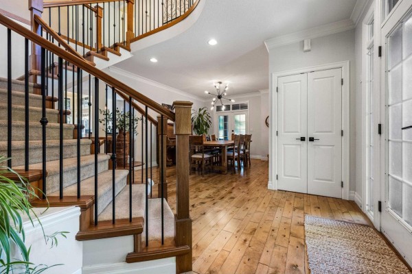 Open-concept space with dining area, kitchen, and living room, featuring hardwood floors and modern appliances - 5782 Garrison Boulevard, Garrison Crossing, Chilliwack