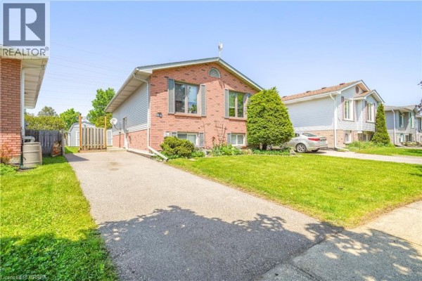 Wooden backyard deck with a barbecue and a grassy lawn. - 58 Arbor Drive, Brantford