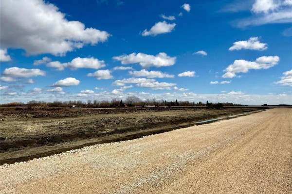 Snowy field with small hills and distant structures in the background - 58 Boyde Road, West St Paul
