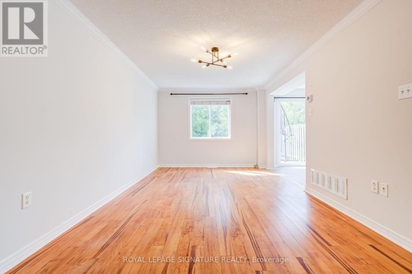 Living room with hardwood floors, white walls, large window and a modern chandelier. - 58 Goodwin Drive, Barrie
