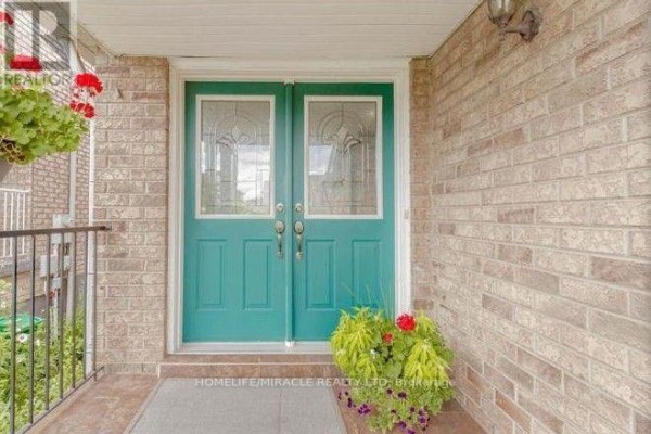 Double teal front doors with glass inserts, flanked by brick and a porch. - 58 Summerdale Crescent, Brampton