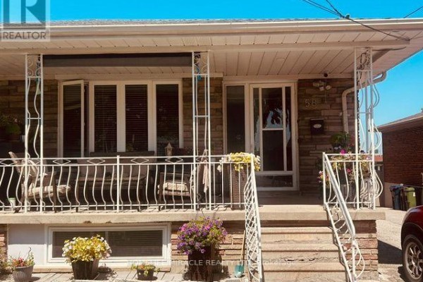 View of the front porch and entrance of a bungalow with seating and plants. - 58 Telco Crescent, Toronto