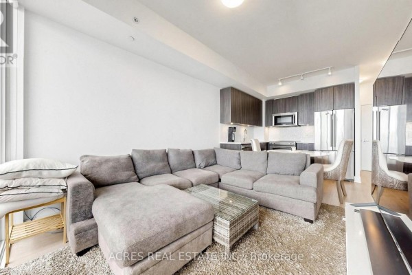 Interior view of a hallway leading to a light wood apartment door. - 5806 - 30 Shore Breeze Drive, Toronto