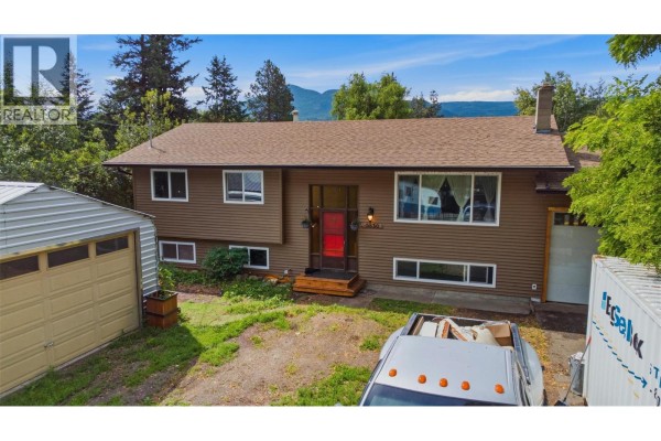 View of the house exterior from the left side showing the garage and yard. - 5830 6 Highway, Lavington