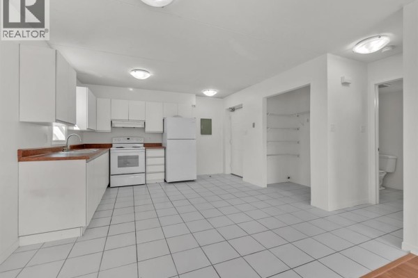 Interior view of a white kitchen with white tile floors and appliances. - 5830 Malden Unit# 107, Lasalle