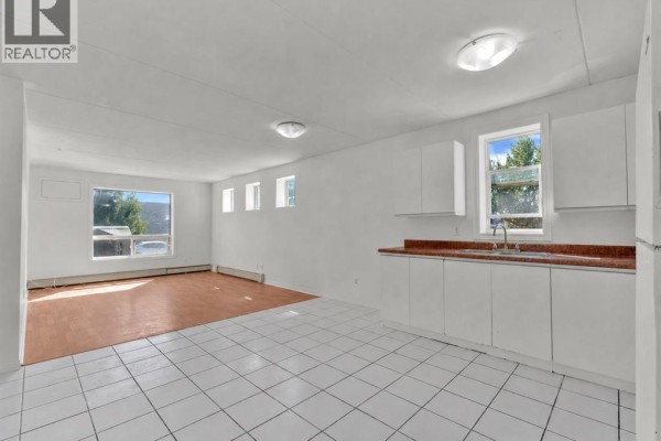 Interior view of a combined living and kitchen area with white tile and wood flooring. - 5830 Malden Unit# 107, Lasalle