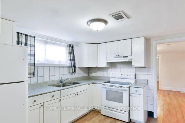 Compact kitchen with white cabinets, countertops, double sink, and white appliances. - 584 Montgomery Street, Oshawa