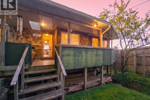 Wooden deck and steps on the exterior of a home with cedar shingle siding. - 585 1st St, Sointula