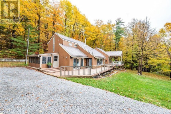 Side view of the property showing a spacious lawn and additional outbuilding. - 585b Two Mile Trail, Whitewater Region