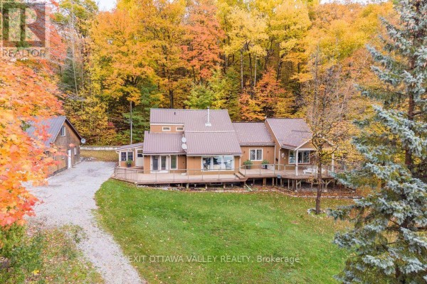 Aerial view of the property with a driveway, surrounded by trees and open space. - 585b Two Mile Trail, Whitewater Region