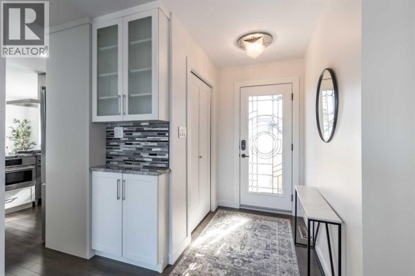 Open living area with fireplace, modern shelving, and view of the kitchen. - 586 Prospect Drive Sw, Medicine Hat