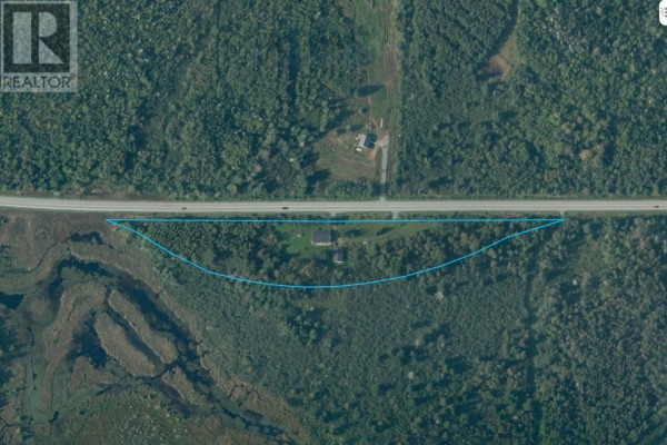 Aerial view of a property with a highway, trees, and water. - 5862 Highway 6, Linden