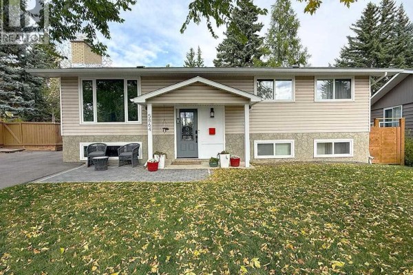 Close-up of the beige siding and stone facade of the split-level house. - 5864 Dalford Hill Nw, Calgary