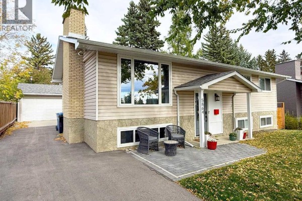 Side view of the house showing the attached garage and driveway. - 5864 Dalford Hill Nw, Calgary