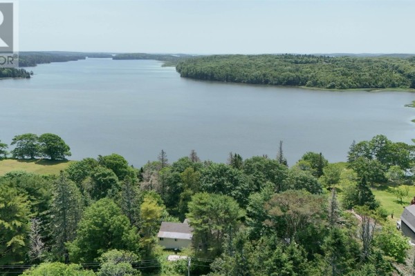 Aerial view of a house surrounded by trees, overlooking a wide lake. - 5881 Highway 3, Glenwood