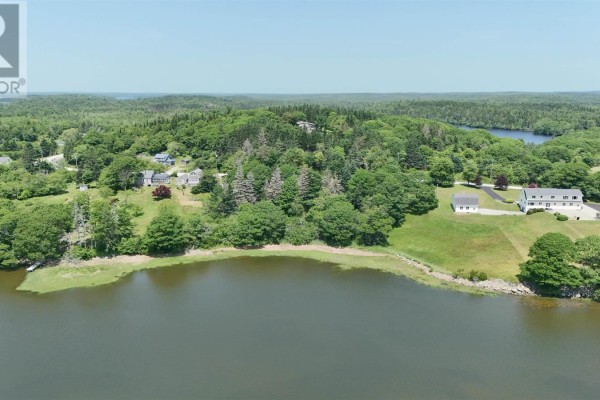 Aerial view of a residential area with houses nestled among trees by a lake. - 5881 Highway 3, Glenwood