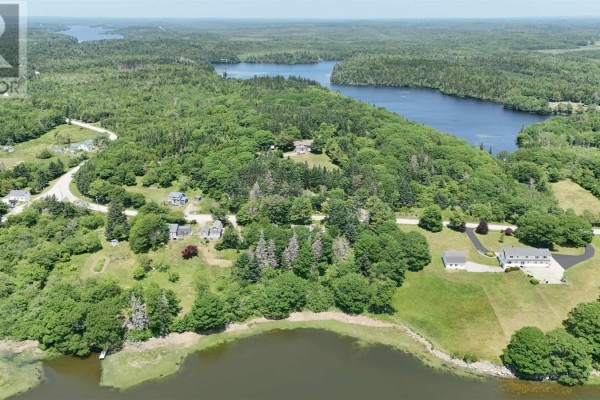 Aerial view of multiple houses and a lake shoreline surrounded by dense green forest. - 5881 Highway 3, Glenwood